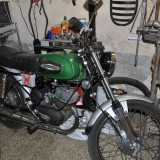 Accanto si trova una Aermacchi Harley Davidson verde e nera del 1974 