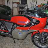 L�uomo ci guida all�interno del suo covo. Ammiriamo un�Agusta MV 350 del 76 rosso che Giovanni considera il suo �gioiellino�