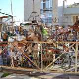 ...il cui figlio Simone, nell�attigua via Massaua crea sculture con pezzi riciclati in un surreale cortile straripante di oggetti tra i pi� disparati