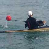 Un canoista raccoglie il pallone con la pagaia