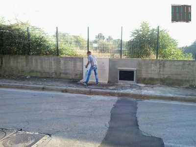 Un ragazzo rom riempie due grossi bottiglioni di acqua