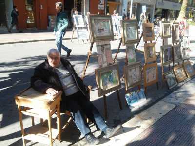 L'artista Michele Gurrado seduto accanto alle sue opere
