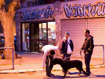 Alcuni tra gli ultimi giovani rimasti di fronte all'ultimo esercizio commerciale ancora aperto