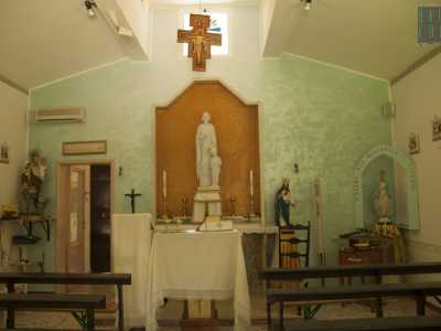 L'interno della cappella � piuttosto semplice, con l'altare avvolto da una parete turchese e puntellato da alcune statue votive