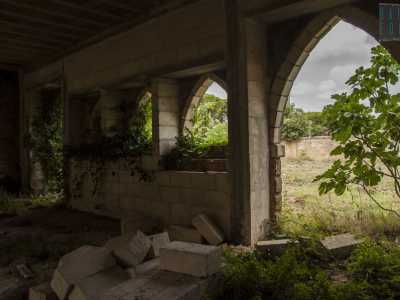 Ci immettiamo nel corridoio che corre lungo la parte posteriore del podere. Quest'ultimo � puntellato da finestre e aperture con archi a sesto acuto, mentre i mattoni sembrano essersi quasi "fusi" con la vegetazione del vicino cortile, donando un fascino particolare all'area
