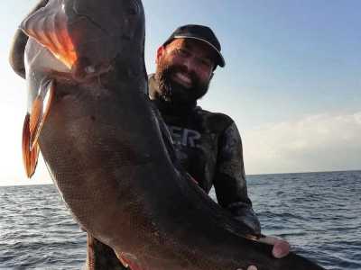 Nico in posa con una cernia bianca di 14 Kg