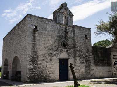 Il semplice tempietto in tufo, dotato di un campanile a vela sormontato da un timpano privo di campana...