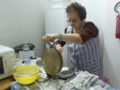 La signora Franca pone la pastella sulla piastra
