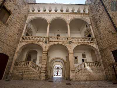 ...in cui spicca una maestosa scalinata contenuta in un volume caratterizzato da sei arcate disposte su due livelli, le cui tre superiori vanno a costituire un loggiato