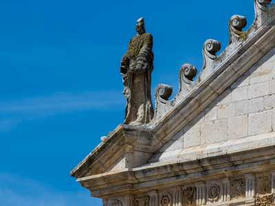 Il prospetto termina con un�ampia quinta triangolare: sui tre vertici sono collocate delle sculture in pietra raffiguranti San Pietro e San Paolo ai lati...