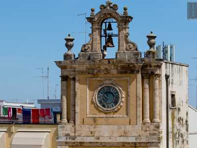 Completamente ristrutturata nell�800, si presenta distinta in tre livelli sovrastati da un arco campanario abbellito da due vasi etruschi. Il terzo piano accoglie due coppie di colonne tuscaniche e il quadrante di colore azzurrognolo