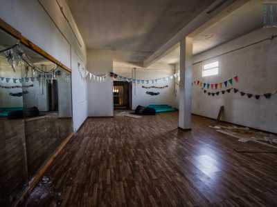 Concludiamo il nostro viaggio in un grande vano col pavimento � in parquet e uno specchio gigante. Appese alle colonne pendono alcuni addobbi per le feste. Qui un tempo era attiva una palestra 