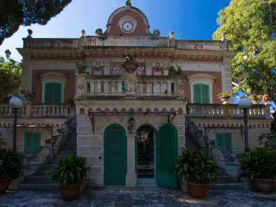 Ora per� � arrivato il momento di entrare. Torniamo al livello inferiore e attraverso una porta ad arco protetta da una persiana verde scendiamo alcuni scalini...