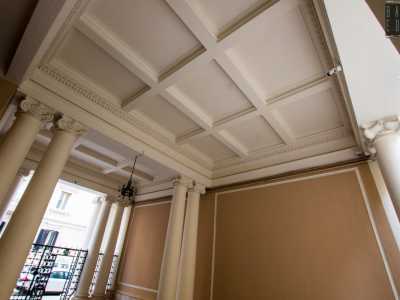 ...contraddistinto dal soffitto con volte bianca a cassettoni da cui pende un lampadario in ferro e da otto colonne  che riprendono lo stile di quelle dell�ingresso