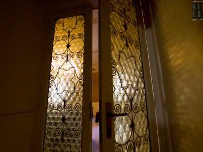 Una porta in legno bianco e con vetri opachi finemente decorati...
