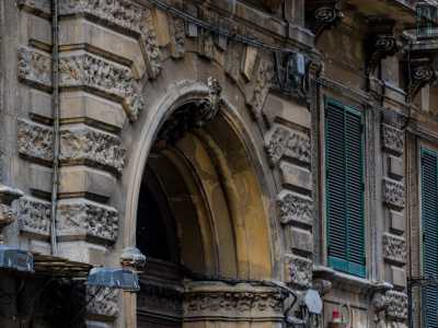 ...quelli pi� lunghi e grezzamente sbozzati si alternano ai pi� piccoli e lisci, andando a incorniciare le porte-finestre chiuse da persiane verdi