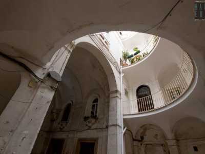 E alzando gli occhi capiamo di trovarci in un luogo diverso dagli altri. I tre livelli del palazzo sono infatti armoniosamente protetti da ringhiere in ferro battuto...