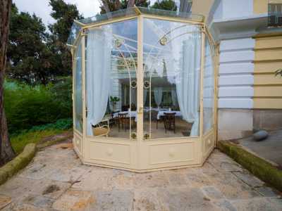 Sulla sinistra, adiacente alla struttura principale, si trova poi un elegante gazebo in stile liberty dai grandi vetri trasparenti impostati su uno scheletro in ferro color ocra, intervallato qua e l� da formelle colorate con motivi geometrici