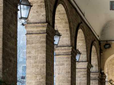 � caratterizzata al primo livello da un lungo e inedito porticato segnato da alte arcate e impostato su lesene laterali e robusti pilastri