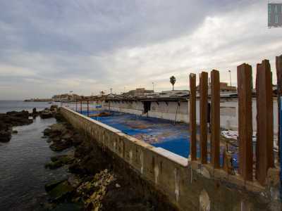 Sul retro dello stabile balza all'occhio la terrazza con vista sull'Adriatico, ormai spoglia, invasa dai detriti e con al centro lo scheletro di un vecchio gazebo