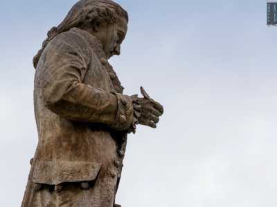 In realt�, ponendosi sul profilo destro di Piccinni e zoomando notevolmente sulla statua, � possibile notare un pezzo rimanente della penna, che quindi pi� che sparita appare spezzata