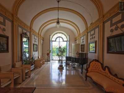 Accediamo quindi al piano terra e veniamo accolti da un ingresso dove decori in stucco come fregi, cornici e specchiature riprendono i motivi geometrici della facciata