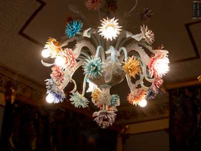 ...da un soffitto ornato da un bassorilievo e impreziosito da un altro lampadario di Murano