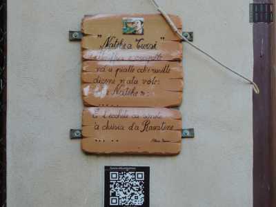 Usciti dalla chiesa siamo colpiti da una tavoletta affissa su un muro sulla quale sono scritti dei versi. � una poesia sulle tradizioni natalizie del paese composta in dialetto tursitano dal poeta locale Albino Pierro, morto a 79 anni nel 1995