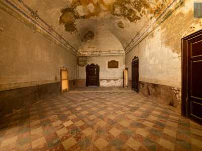 Raggiungiamo quindi il piano nobile e accediamo da una porta in legno a un ampio salone con un�alta volta anch�essa rovinata dall�incuria