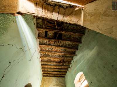 In una stanza adiacente invece, alzando lo sguardo, scopriamo un bellissimo soffitto a cassettoni in legno finemente decorato con motivi a fiori in parte consumato