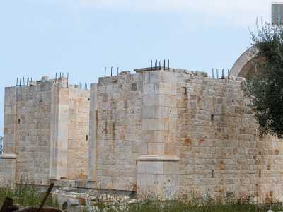 Sulla destra notiamo anche un fabbricato finito solo per met�. Le colonne che ne delimitano la facciata, assieme al tetto a cupola incompleto, ci fanno supporre possa trattarsi di una chiesa...