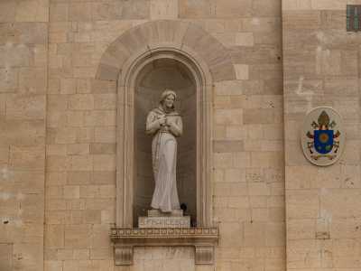 ...e San Francesco costeggiare il portale ligneo sormontato da un frontone rettangolare