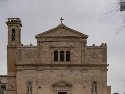 Davanti a noi si profila la candida facciata della chiesa dai tratti neoclassici scandita in due parti