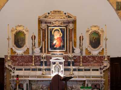 Spostando lo sguardo a destra possiamo ammirare l�altare maggiore del XVIII secolo: policromo e decorato con lunghi candelabri dorati...