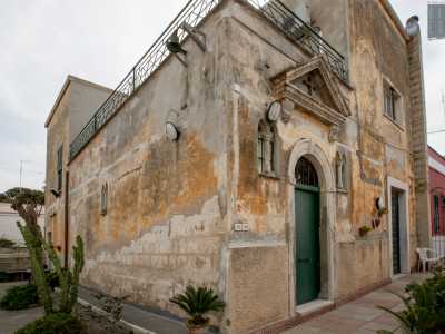 Per un attimo ci addentriamo nel vicolo V dell'arteria, laddove un muretto rossiccio protegge la cappella Moschetti, grazioso luogo di culto del 1922 con una vistosa croce inserita nel timpano
