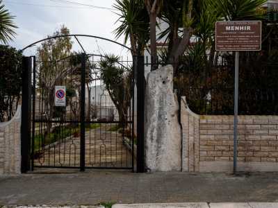 In via Titolo, incastonato nella recinzione di una villa, spunta a sorpresa uno di quei menhir millenari troppo spesso lasciati all'incuria