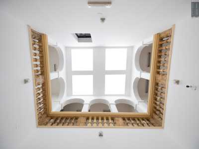 Giunti al primo livello svoltiamo a destra attraversando uno stretto corridoio e approdiamo in un ampio e alto spazio chiuso da un soffitto con quattro lucernari moderni