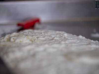 Il risultato � la cagliata, una pasta semi molle che si posa sul fondo del tino di coagulo, facendo venire in sospensione il siero. Tolto quest�ultimo, viene messa sul banco da lavoro, si aggiunge del sale e dell�acqua di circa 100 gradi e... 