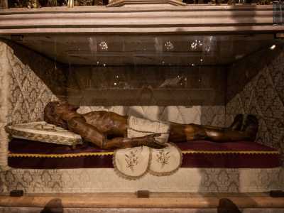 ... mentre nella parte retrostante una teca in vetro custodisce il suo corpo dilaniato dalle ferite  