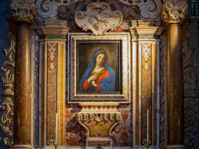 Qui il dipinto di una dolce e sommessa Maria col manto blu e le mani giunte � incluso tra capitelli compositi, un grande fregio a volute e uno stemma con la colomba bianca, simbolo appunto di purezza