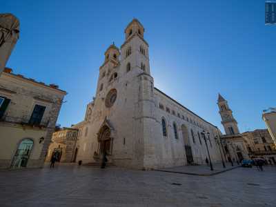 Qui incontriamo la facciata in pietra bianca dell�edificio, chiusa dalle due torri campanarie in stile romanico che sovrastano un magnifico rosone e un portale decorato