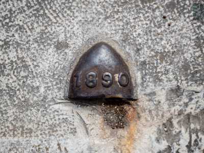 ...ai cui piedi notiamo una pietra miliare. Riporta una data: 1890