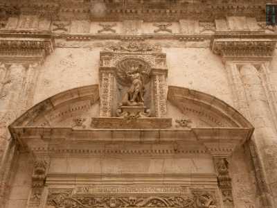 Il tutto � sormontato da un architrave con il timpano interrotto da una nicchia che racchiude la statua dell'Arcangelo Gabriele, attorniato naturalmente da teschi e ossa