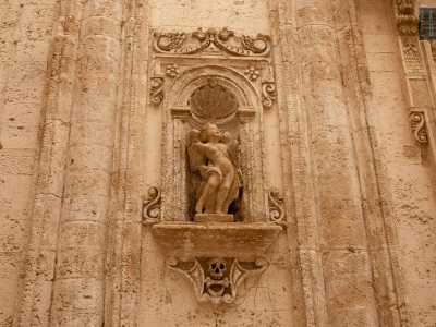 ...si aprono infatti due nicchie contenenti statue di putti con in basso due teschi e un osso tra i denti