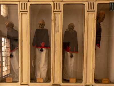 ...dentro le quali sono posti nove corpi mummificati vestiti con tuniche bianche, nere e rosse