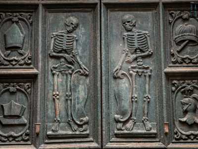 ...mentre al centro due scheletri speculari reggono delle pergamene, ricordando che davanti alla morte siamo tutti uguali a prescindere dal nostro ceto sociale