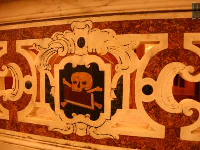 Oltre questa lastra � presente un parapetto in marmo policromo con raffigurazioni di teschi ocra su sfondo nero che delimitano la zona occupata dall�elegante altare