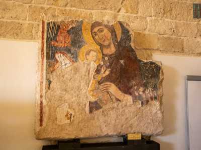 Ed ecco, oltre i tavoli e le librerie, fare subito mostra di s� una lastra litica con un affresco del XIV secolo raffigurante la Madonna col bambino