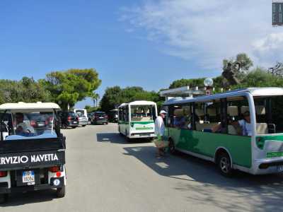 Superando un sottopassaggio ci ritroviamo in un parcheggio di colorati taxi e bus elettrici, con i conducenti in attesa dei bagnanti da portare in spiaggia