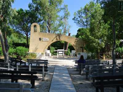 Proseguendo verso l�uscita del villaggio, passiamo infine davanti a una chiesetta all�aperto immersa in un boschetto e costituita da un arco asimmetrico con altare e vari posti a sedere